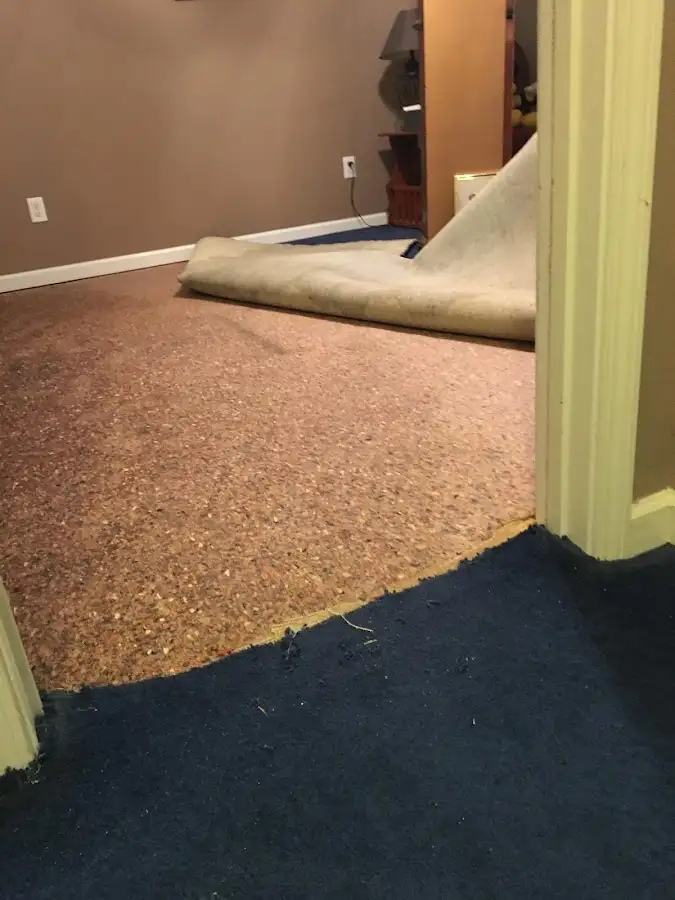Carpet pad removal revealing water damage during Water Mitigation Services in Glassmanor